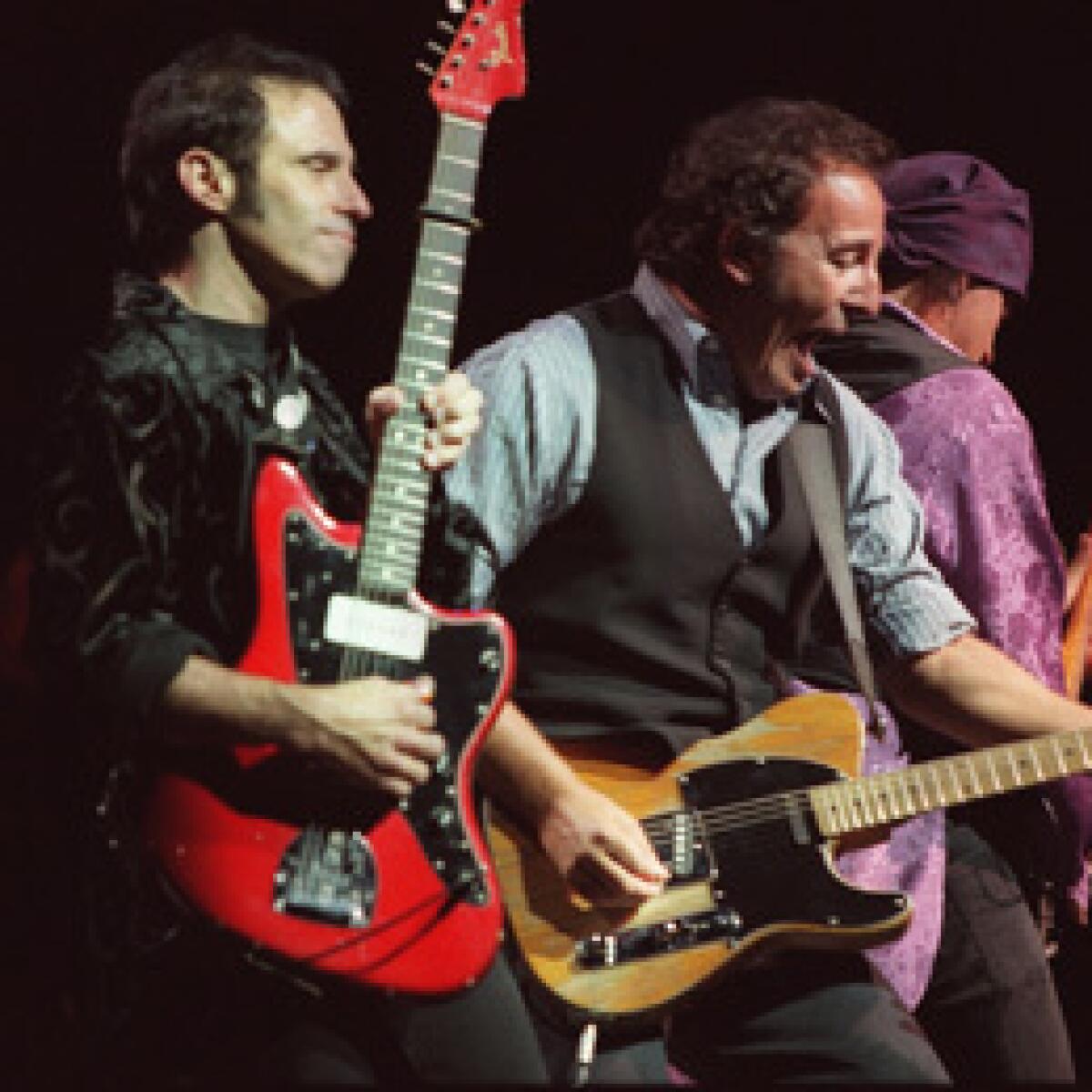 Nils Lofgren, left, playing with Bruce Springsteen and his E Street Band.