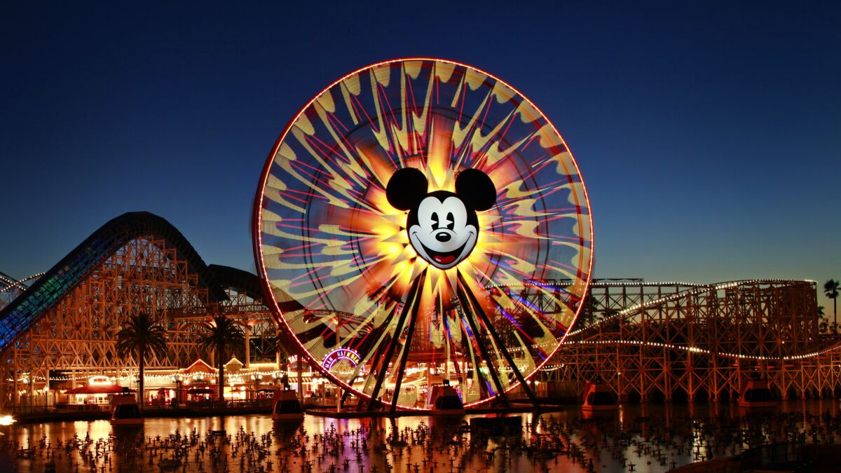 Mickey's Fun Wheel and the California Screamin' roller coaster are seen at dusk at Disney California Adventure Park.