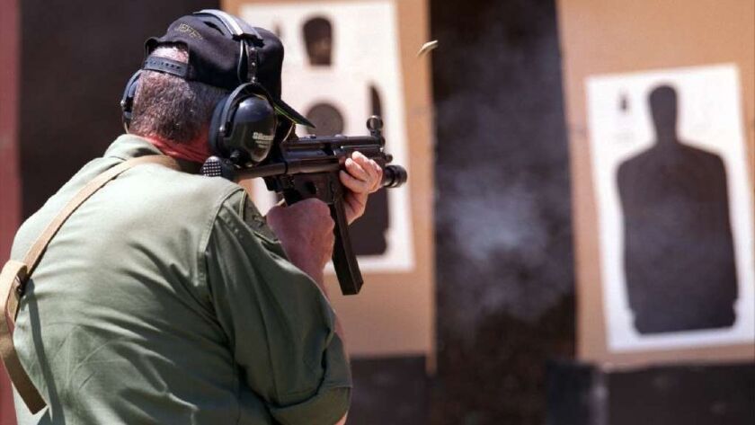 A SWAT team member shoots a target with a 9mm automatic rifle. A Huntington Beach resident is seeking signatures for a petition that would ban automatic and semiautomatic weapons in the city.