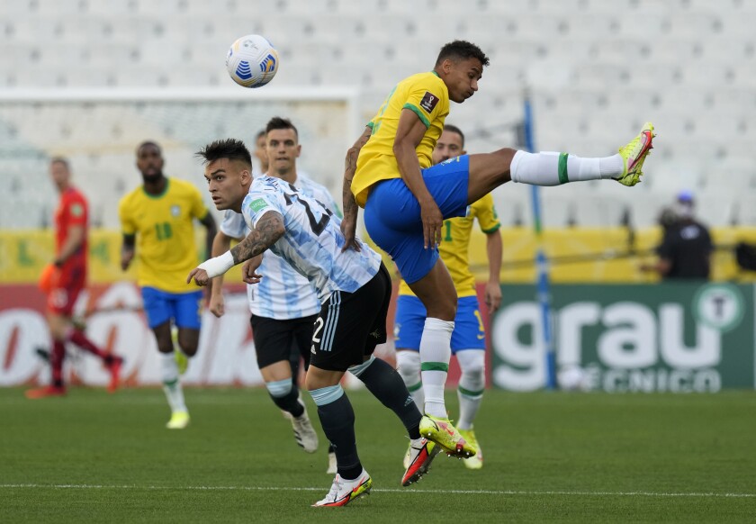 Argentina's Lautaro Martinez, left, and Brazil's Danilo fight for the ball during a qualifying soccer match.