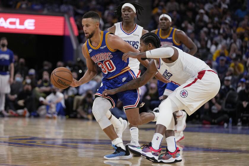 Golden State Warriors guard Stephen Curry (30) dribbles around Los Angeles Clippers guard Paul George.