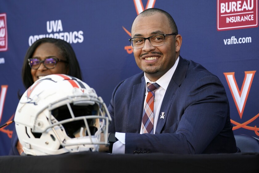 New Virginia head football coach and longtime Clemson assistant coach Tony Elliott, right, speaks during an introductory NCAA college football news conference, along with athletic director Carla Williams, at the school, Monday, Dec. 13, 2021, in Charlottesville, Va. Elliott will take over the program after the upcoming bowl game. (AP Photo/Steve Helber)
