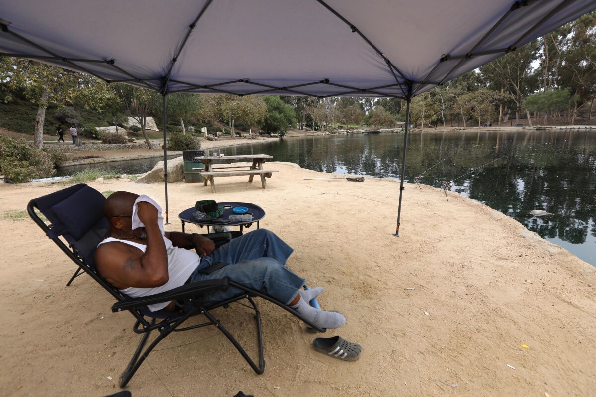 Alonzo Frazi wipes the sweat from his face while fishing at Kenneth Hahn State Recreation Area.