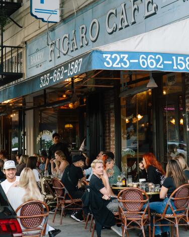 Customers enjoy dinner on the sidewalk of popular cafe Figaro Bistrot 