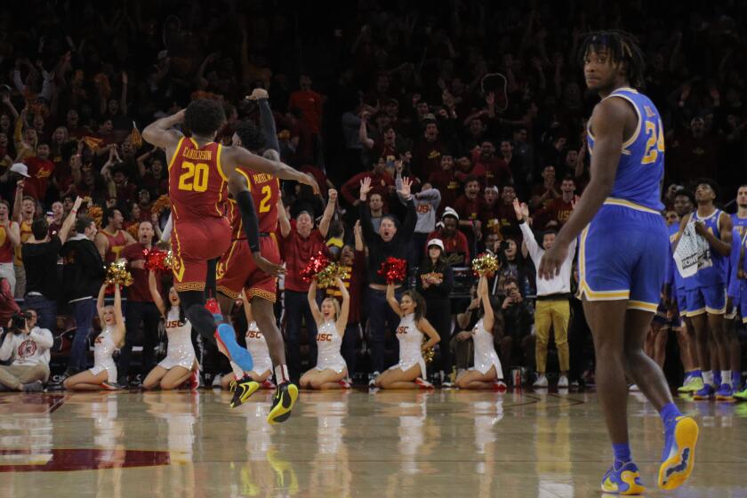 LOS ANGELES, CA - MARCH 7, 2020: USC Trojans guard Jonah Mathews (2) reacts towards the crowd with USC Trojans guard Ethan Anderson (20) after scoring the game winning 3-point shot to beat UCLA in the final moments at Galen Center on March 7, 2020 in Los Angeles, California. UCLA Bruins forward Jalen Hill (24) turns to look at the scoreboard as time expires.(Gina Ferazzi/Los AngelesTimes)