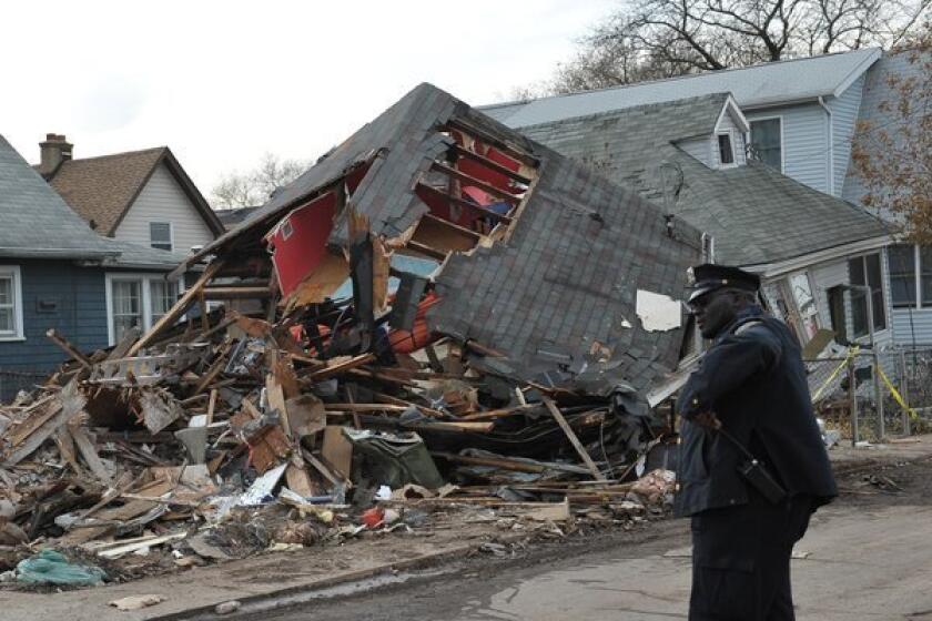 A police officer stands outside a collapsed house on Staten Island. Parts of Staten Island and Long Island remained without power in the aftermath of Sandy.