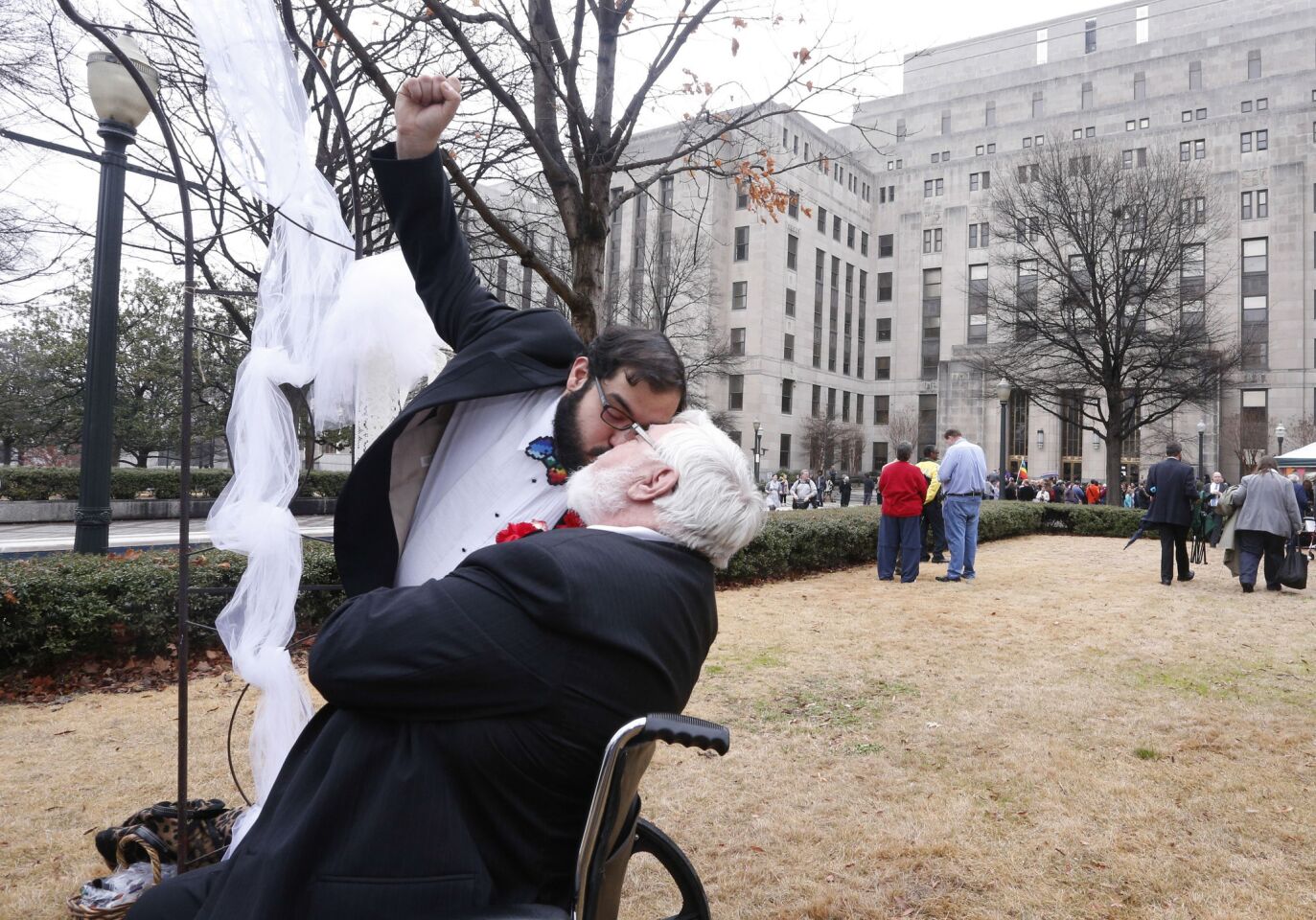 Eli Wright raises his fist as he kisses his spouse, Don Wright, in Linn Park after their marriage in Birmingham, Ala.
