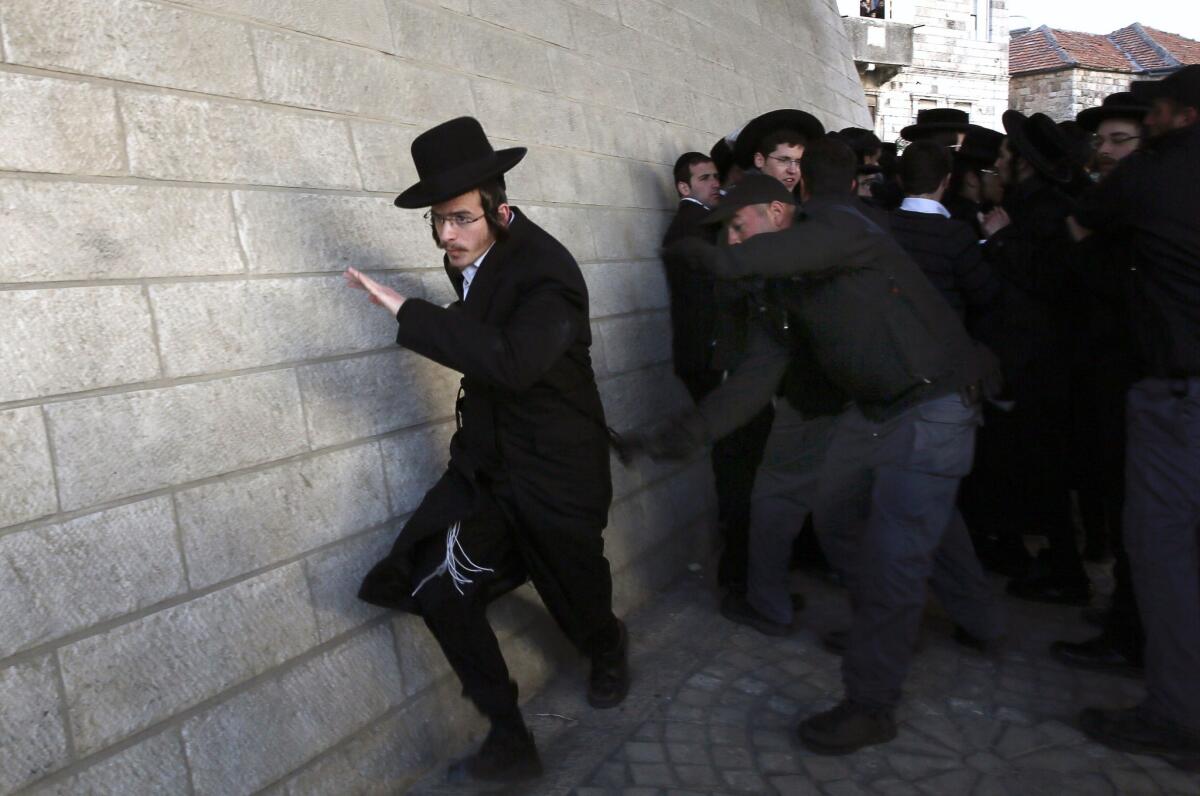 Israeli policemen scuffle with ultra-Orthodox Jews during a protest Thursday in Jerusalem against their young men being called up for military service.
