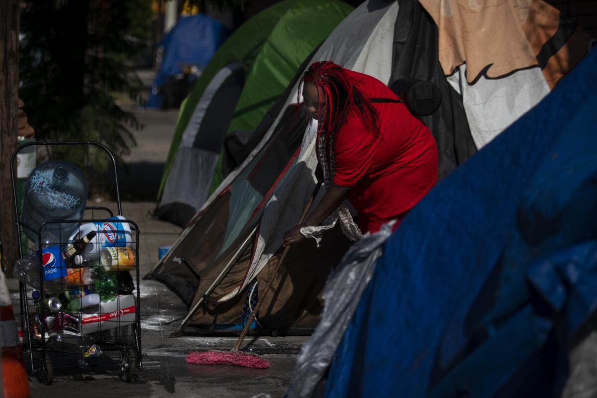 Leneace Pope, 34, known as Niecy is cleaning outside of her tent on the sidewalk in Los Angeles, Calif. on Monday, November 12, 2019.