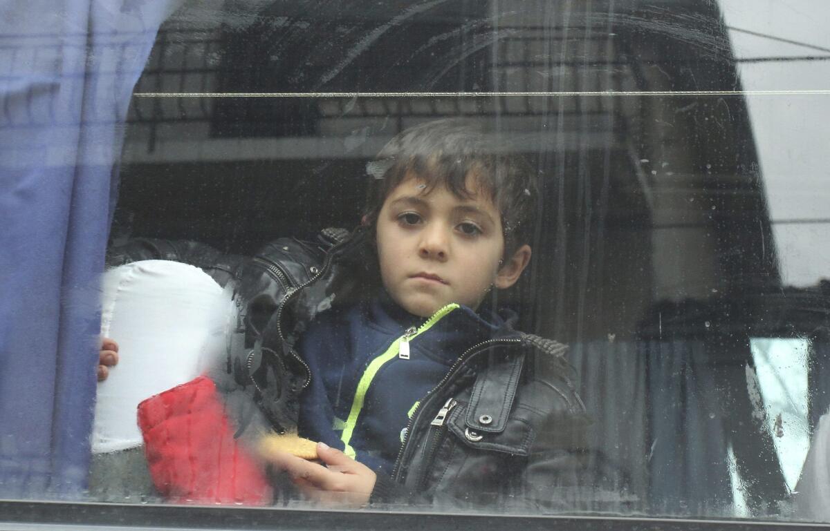 Un niño refugiado sirio observa desde la ventana de un autobús que le traslada hasta la frontera entre Serbia y Croacia, tras registrarse en el centro de Presevo, Serbia, hoy, 24 de noviembre de 2015. El número de refugiados que pasan por la ruta de los Balcanes a través del eje Serbia-Austria se ha reducido notablemente desde que el pasado jueves varios países comenzarán a bloquear el paso a quienes consideran "emigrantes económicos", es decir a todos los que no son sirios, iraquíes o afganos. Unos 800.000 refugiados han llegado a Europa en lo que va de año, de los que unos 660.000 has pasado por la ruta de los Balcanes.