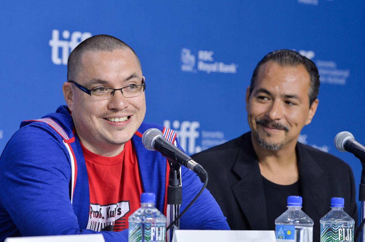 Two men sit at microphones for a film festival session.