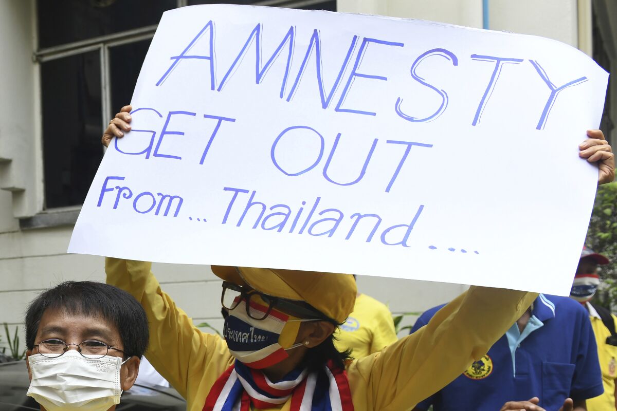Thai royalists protesters hold a sign against Amnesty International Thailand during the protest in Bangkok, Thailand, Thursday, Nov. 25, 2021. Royalist activists in Thailand say they will present a petition with 1.2 million signatures to the government on Thursday, Feb. 17, 2022, calling for it to shut down the country’s branch of the human rights organization Amnesty International. (AP Photo/Panumas Sanguanwong)