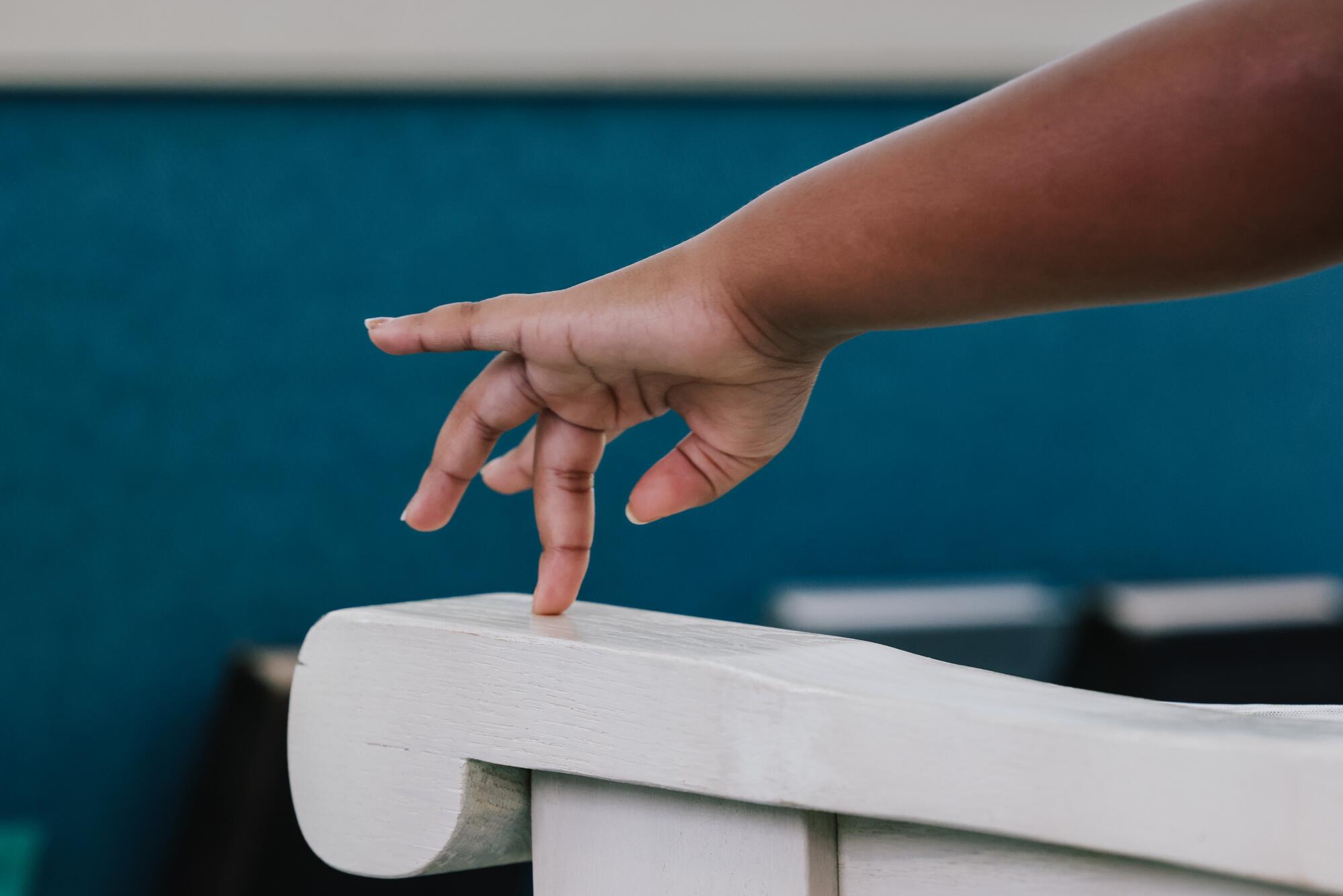 A young girl moves her fingers along an armrest during a Sunday service at the Third Church of Christ, Scientist.