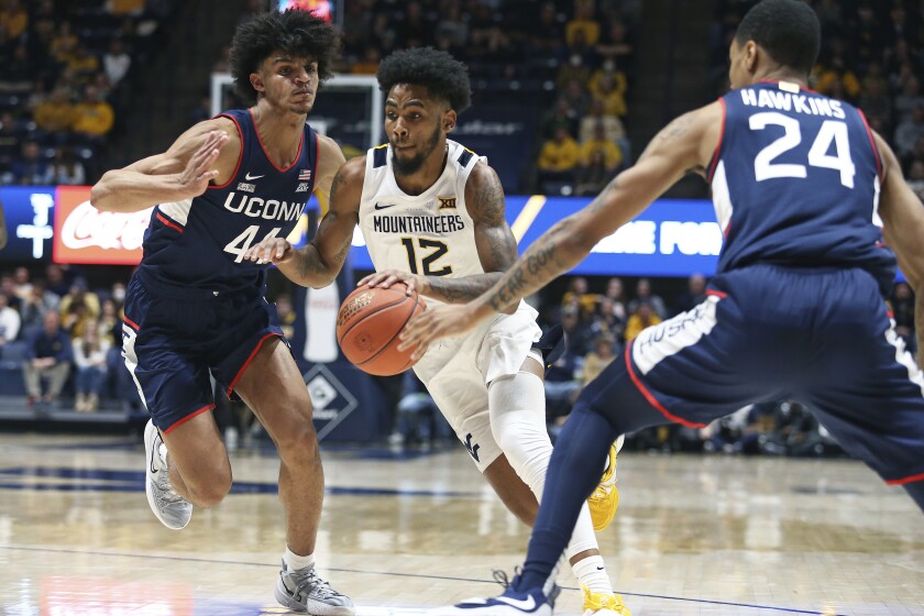 West Virginia guard Taz Sherman (12) is defended by Connecticut guards Andre Jackson (44) and Jordan Hawkins (24) during the second half of an NCAA college basketball game in Morgantown, W.Va., Wednesday, Dec. 8, 2021. (AP Photo/Kathleen Batten)