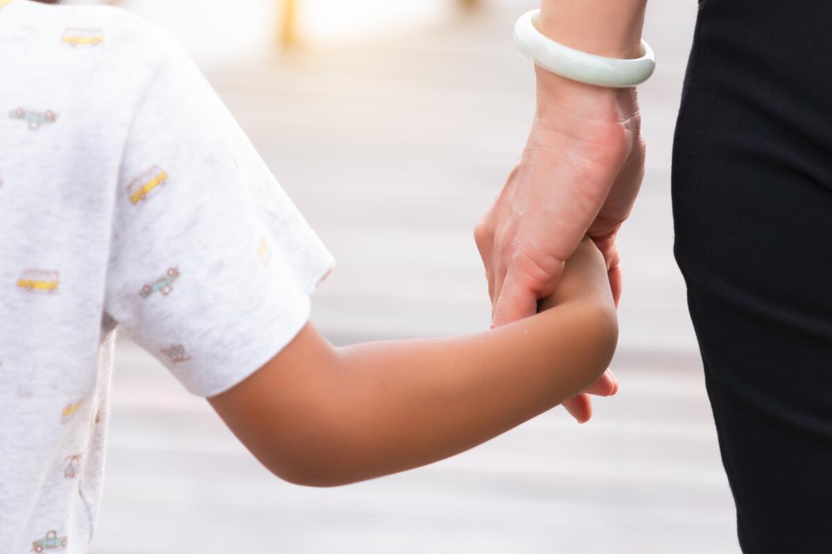 A little girl holds her mother's hand 