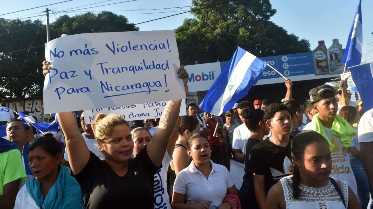 A demonstrator holds a placard reading "No More Violence! Peace and Tranquility for Nicaragua!" during a march on April 23, 2018, demanding that Nicaraguan President Daniel Ortega and his wife, Vice President Rosario Murillo, step down.