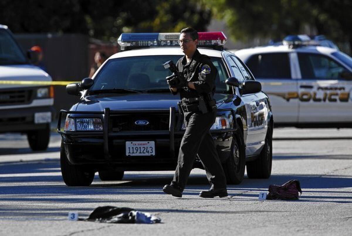 Pomona police investigate after a young woman was shot Nov. 13, 2013, by a man with a shotgun while walking on the street with a companion.