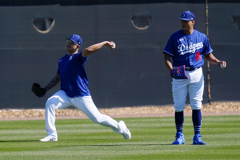 Dodgers pitchers Julio Urías and Victor Gonzalez warm up during a spring training workout.