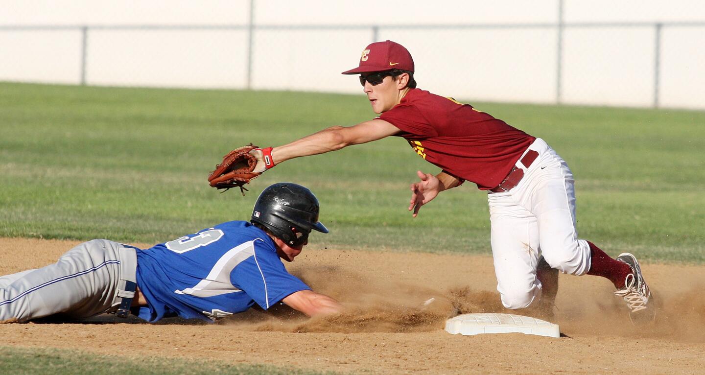 La Canada's Christian Heer catches the pick-off throw but Burbank's Cameron Briggs who dives safely back to second base in a summer league baseball game at La Canada High School on Thursday, July 3, 2014.