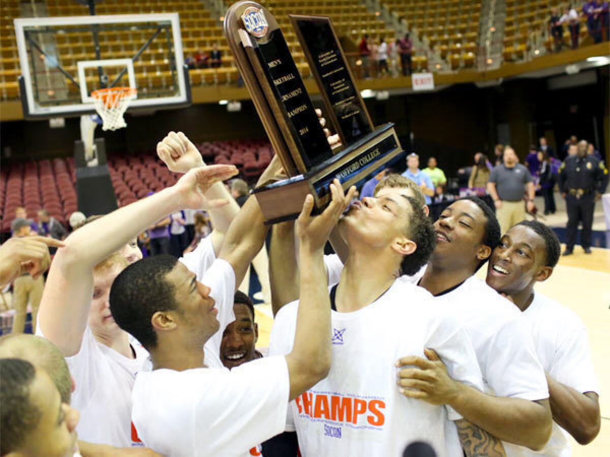 Wofford's Lee Skinner, center, kisses the trophy after he and his teammates defeated Western Carolina in the Southern Conference championship game in Asheville, N.C.