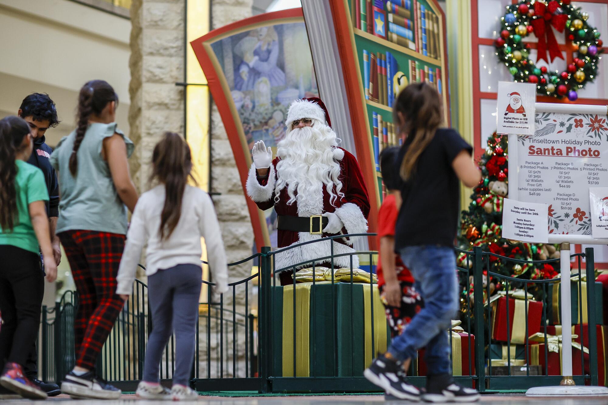 Santa greets the Herrera family as they prepare for a photo session at the Puente Hills Mall.