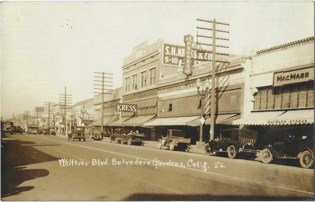 A sepia-tone photograph shows cars parked along a commercial street, with a JC Penney store in the center of the frame