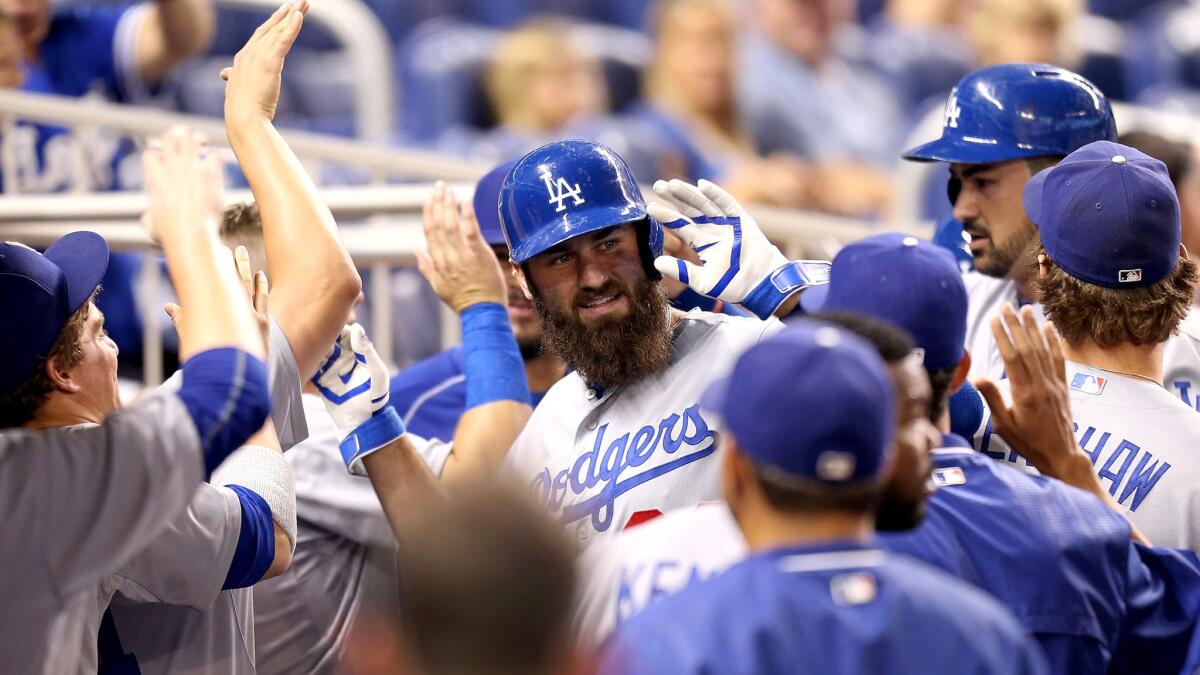 Dodgers left fielder Scott Van Slyke is congratulated by teammates after hitting a two-run home run against the Marlins in the second inning Friday night in Miami.