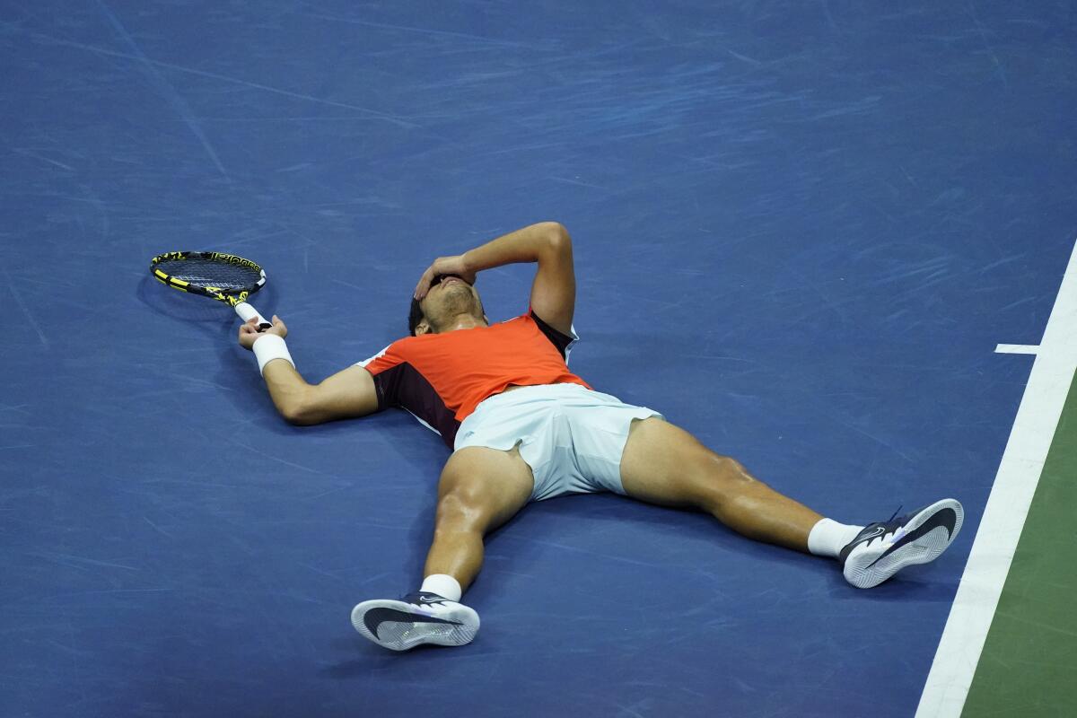 Tennis player Carlos Alcaraz lying sprawled on court