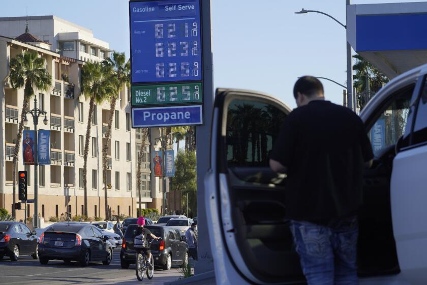 A motorist pauses at a gas station displaying higher gasoline prices at a Chevron station downtown Los Angeles Friday, Feb. 18, 2022. Gas prices are up nearly 40% from a year ago and more than 6% over the past month, according to AAA. Suspending the federal tax of 18.4 cents a gallon would not offset the price increases that occurred recently as Russia threated Ukraine. And there is no guarantee that energy companies would pass all of the savings on to consumers. (AP Photo/Damian Dovarganes)