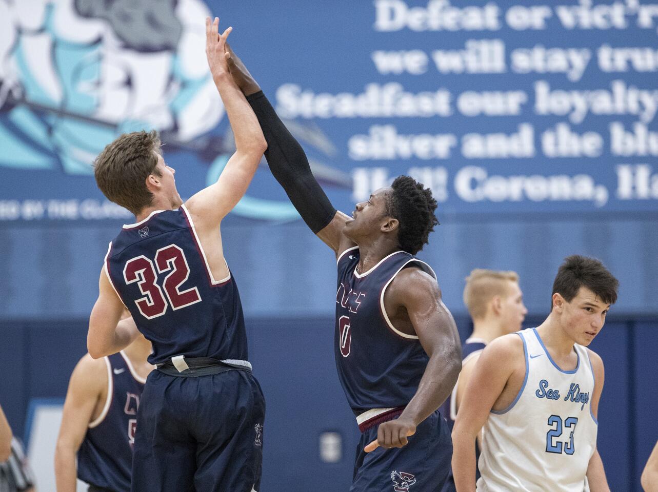 Capistrano Valley Christian's Luke Powell, left, and Festus Ndumanya high-five as Corona del Mar's Jack Stone walks off the court during a Coach Mike's Long Shot Challenge game on Monday.
