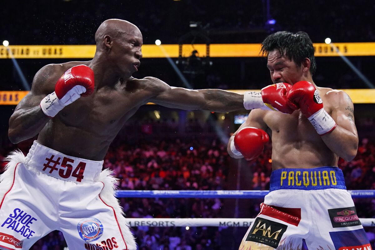 FILE - Yordenis Ugás, of Cuba, hits Manny Pacquiao, of the Philippines, in a welterweight championship boxing bout Aug. 21, 2021, in Las Vegas. Ugás faces Errol Spence Jr. in a unification bout Saturday, April 16. (AP Photo/John Locher, File)