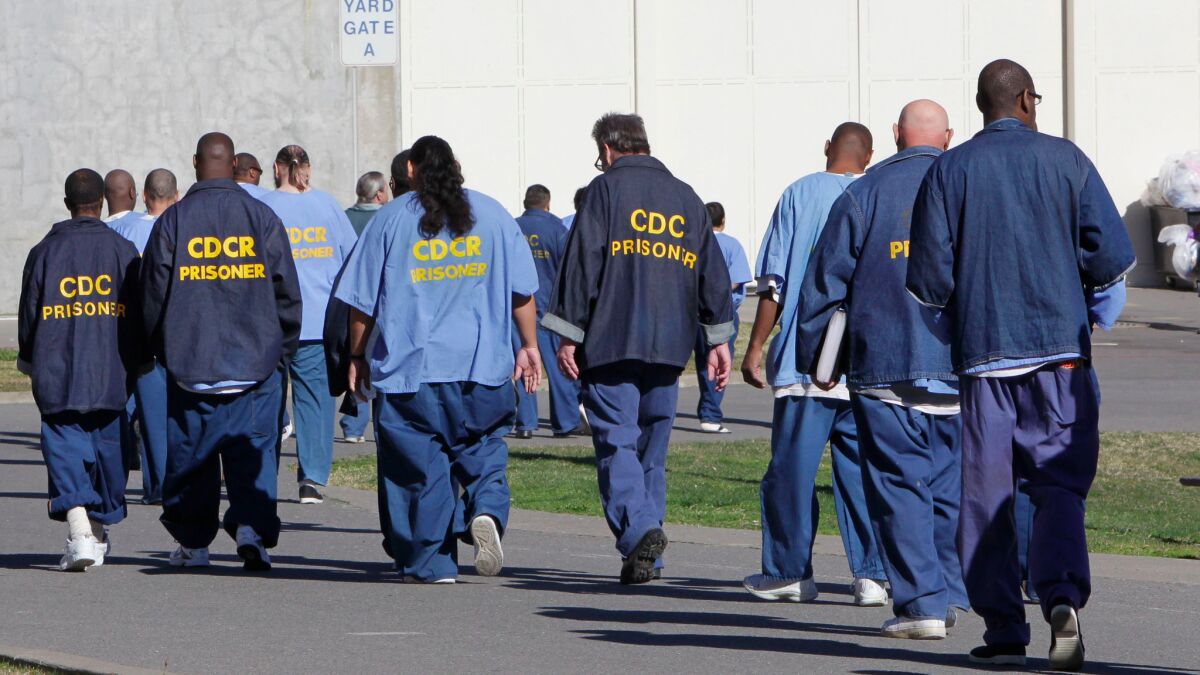 Prisoners walk through the exercise yard at California State Prison Sacramento, near Folsom, in 2013.