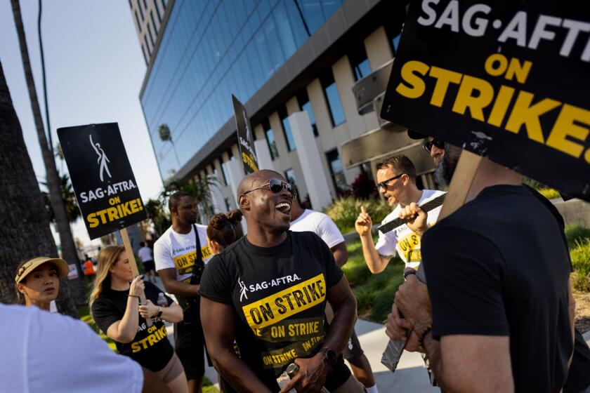 Los Angeles, CA - October 18: Actor Wole Parks, most recently seen in TV's "Superman & Lois," chats with fellow picketers as another day striking ends in front of the Netflix offices, in Los Angeles, CA, Wednesday, Oct. 18, 2023. Actors have been on strike since July 14, 2023. (Jay L. Clendenin / Los Angeles Times)