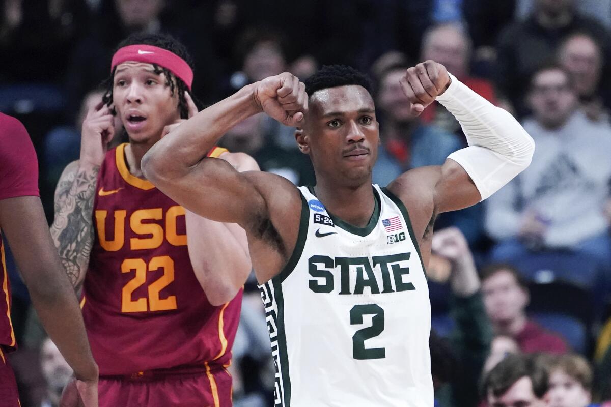 Michigan State guard Tyson Walker flexes in front of USC's Tre White during an NCAA tournament game 