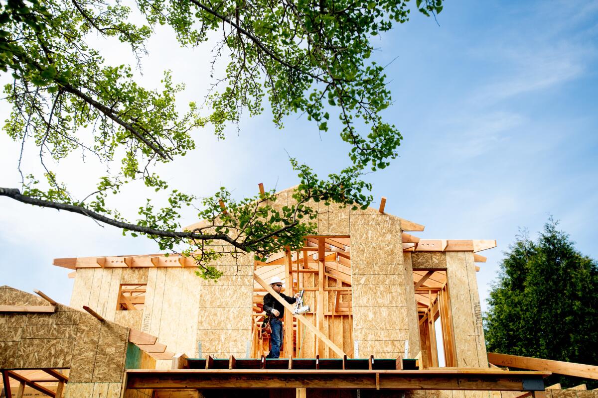 A construction worker builds a single-family home in Palo Alto in April. Several state legislative proposals have aimed to increase home-building in wealthy communities.