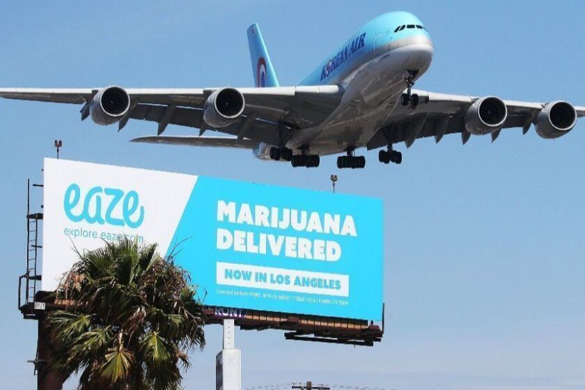 LOS ANGELES, CA - JULY 12: An airplane descends to land at Los Angeles International Airport above a billboard advertising the marijuana delivery service Eaze on July 12, 2018 in Los Angeles, California. A number of marijuana delivery apps are available in the state. Recreational use of marijuana became legal in California on January 1. (Photo by Mario Tama/Getty Images) ** OUTS - ELSENT, FPG, CM - OUTS * NM, PH, VA if sourced by CT, LA or MoD **