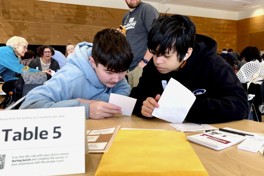 Meadowdale High School 9th grade students Juanangel Avila, right, and Legacy Marshall, left, work together to solve an exercise at MisinfoDay, an event hosted by the University of Washington to help high school students identify and avoid misinformation, Tuesday, March 14, 2023, in Seattle. Educators around the country are pushing for greater digital media literacy education. (AP Photo/Manuel Valdes)