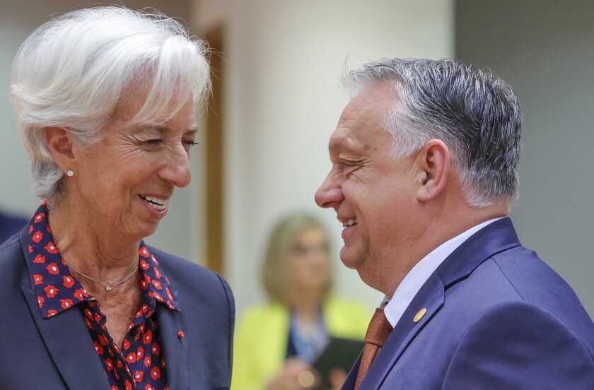 European Central Bank President Christine Lagarde, left, speaks with Hungary's Prime Minister Viktor Orban during a round table meeting at an EU summit in Brussels, Friday, June 24, 2022. EU leaders were set to discuss economic topics at their summit in Brussels Friday amid inflation, high energy prices and a cost of living crisis. (AP Photo/Olivier Matthys)