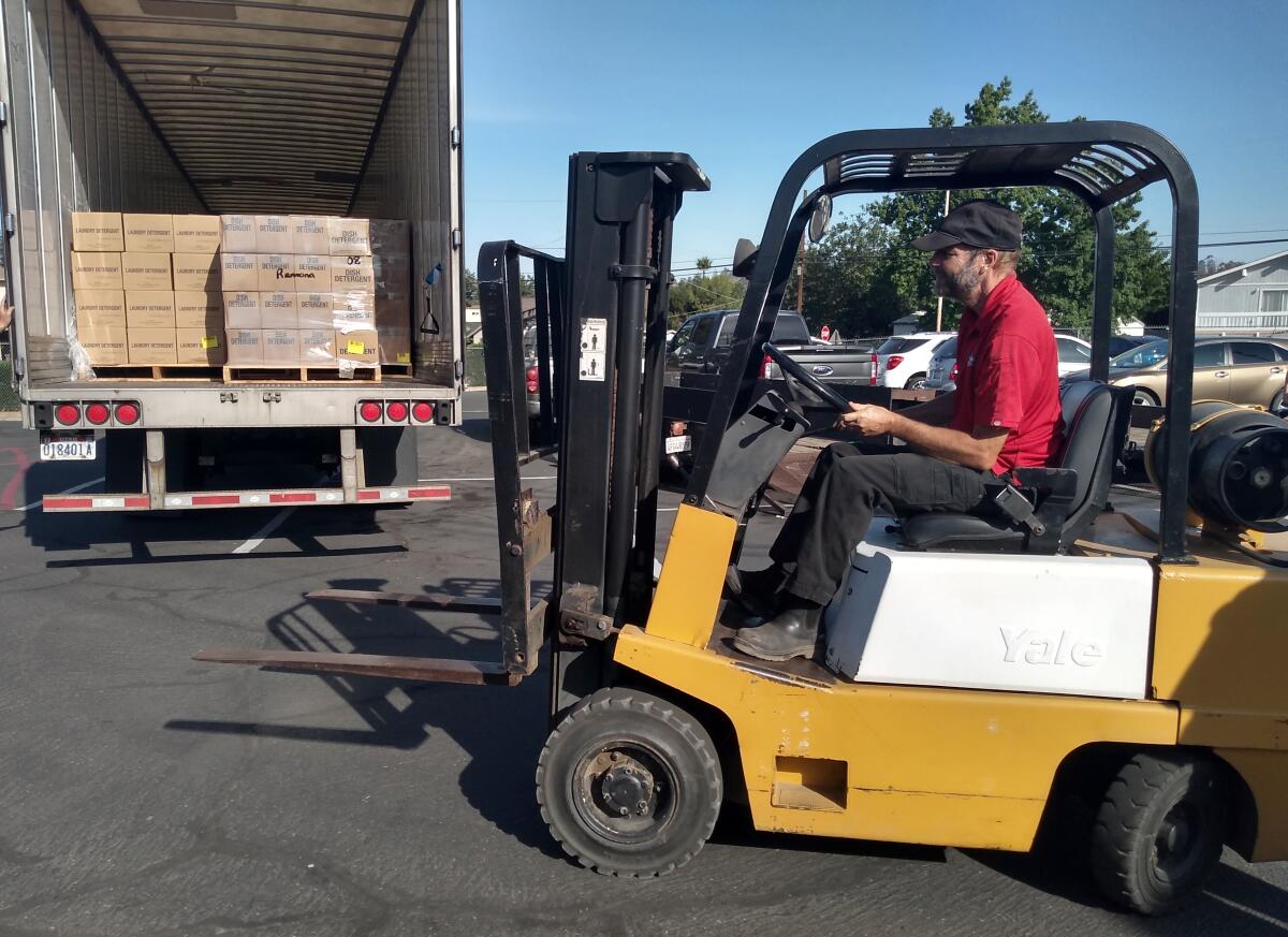 Piva Equipment Services of Ramona Fork Lift Driver Mark Snavely helps unload boxes off the truck.
