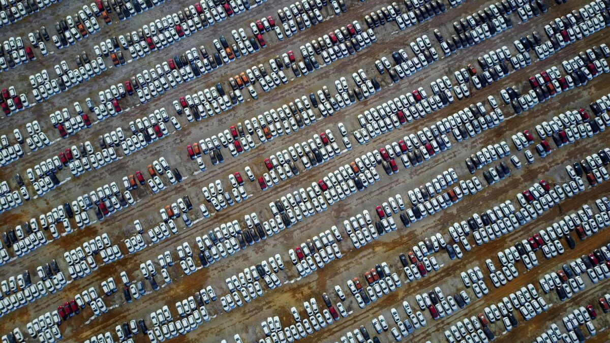 This aerial photo shows new cars in a parking lot in Shenyang, northeast China's Liaoning province. China recorded an unexpected 60.36 billion yuan trade deficit in February, activity at as factories and ports slowed during the Lunar New Year holiday.