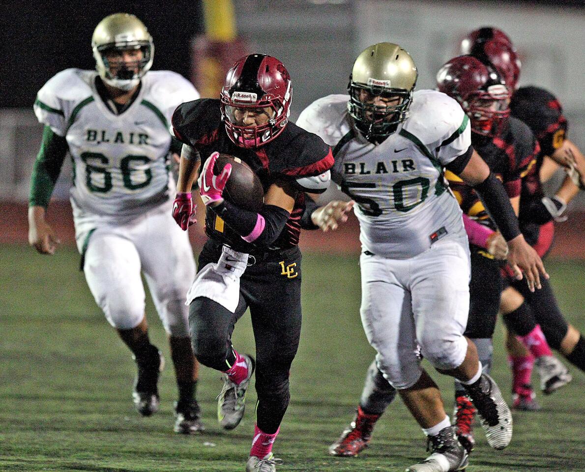 La Canada's David Yoon outruns Blair defenders Xavier Guerrero and Dominick Livingston for a 98-yard touchdown during a game on Thursday, October 22, 2105.