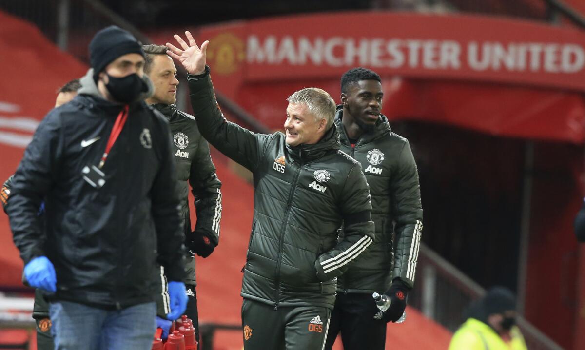 Manchester United's manager Ole Gunnar Solskjaer waves towards the directors box as he walks to the technical area ahead of the English Premier League soccer match between Manchester United and Aston Villa at Old Trafford in Manchester, England, Friday, Jan. 1, 2021. (Lindsey Parnaby/ Pool via AP)