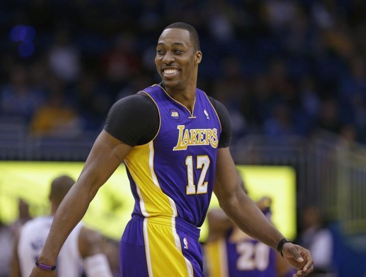 Lakers big man Dwight Howard smiles as he walks on the court in Orlando after a timeout late in the fourth quarter Tuesday.