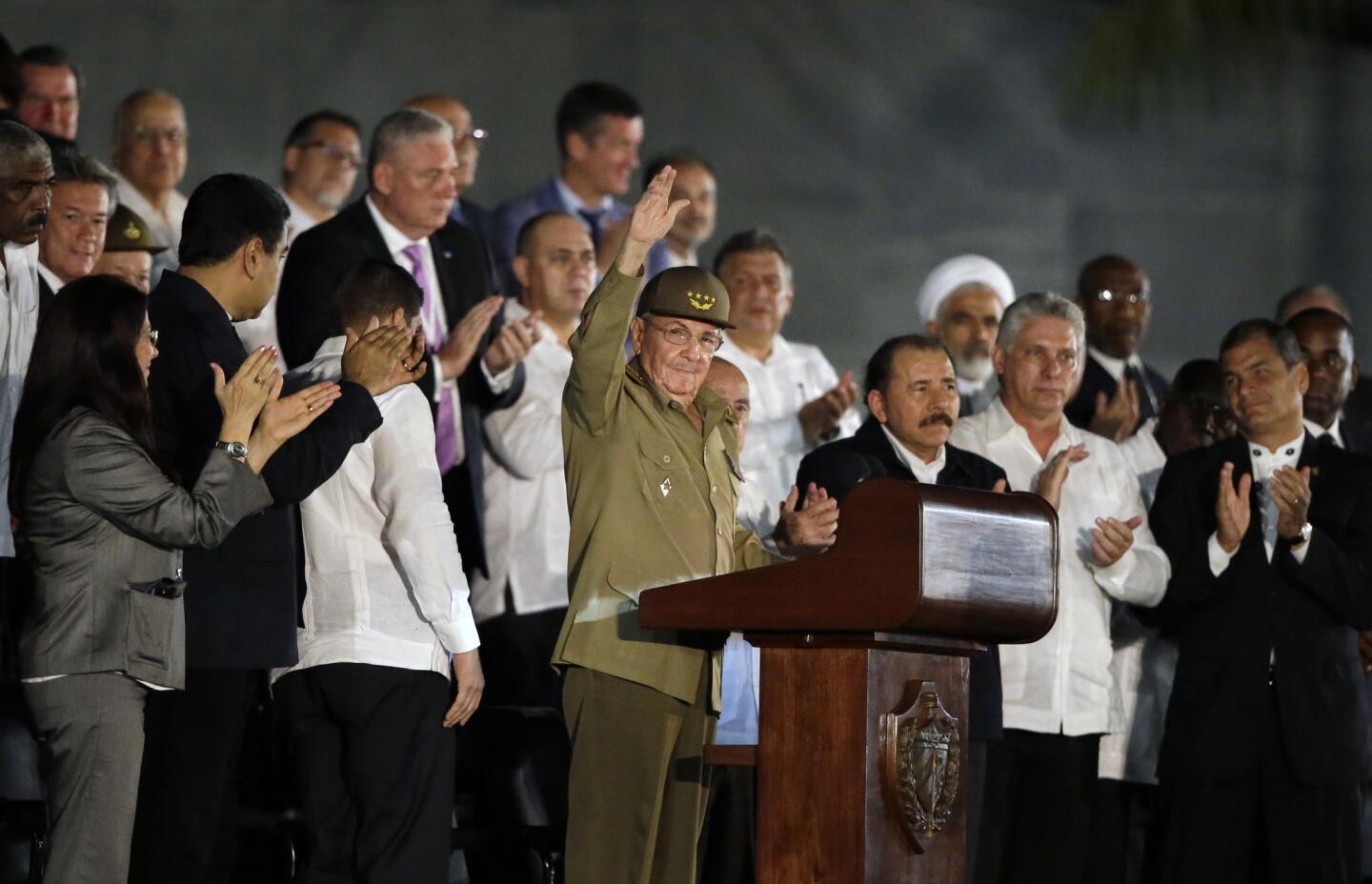 Cuba's President Raul Castro, center, salutes as he arrives at a rally honoring his brother Fidel Castro, who died Friday, at the Revolution Plaza in Havana Tuesday night.