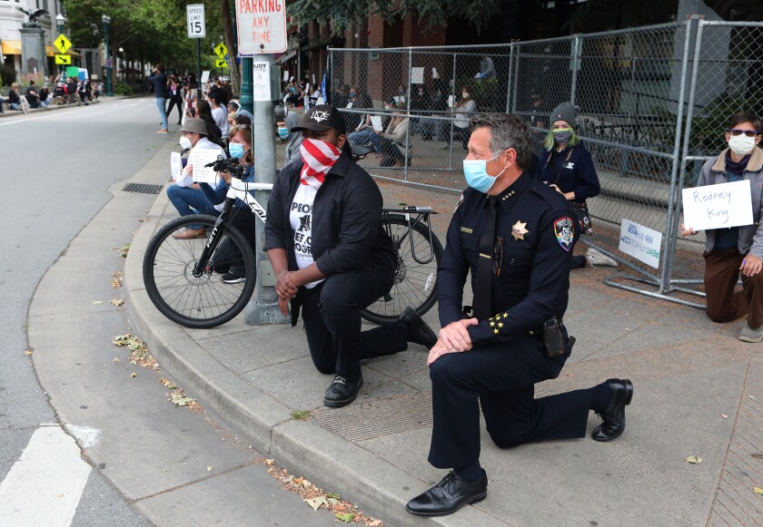 Santa Cruz Mayor Justin Cummings and Police Chief Andrew Mills take a knee along with hundreds gathered Saturday on Pacific Avenue in downtown Santa Cruz to honor the memory of George Floyd and bring attention to institutionalized police violence against black people.