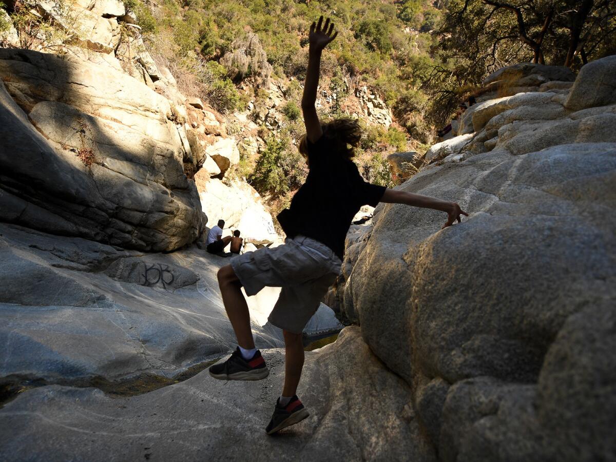 A boy plays on slippery rock at Hermit Falls in the San Gabriel Mountains Saturday.