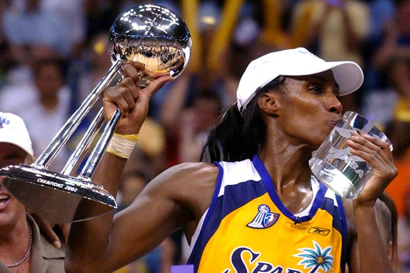 Los Angeles Sparks' Lisa Leslie kisses her MVP trophy after the Sparks beat New York Liberty, 69-66, in 2002.