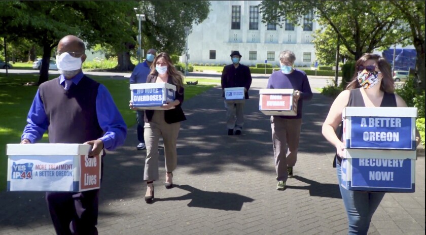 Volunteers deliver boxes of signed petitions in favor of the measure to the Oregon Secretary of State's office in Salem, Ore.