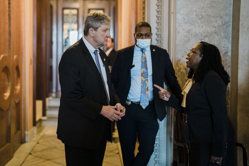 Senator John Kennedy, left, talks with Ketanji Brown Jackson, right, in a hallway 