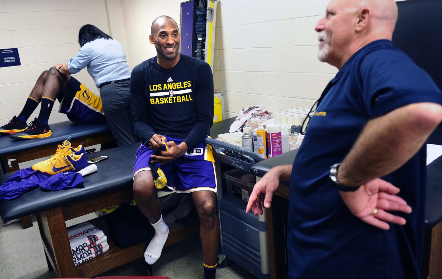 Kobe Bryant and trainer Gary Vitti share a laugh in the locker room before a game against the Rockets in Houston.